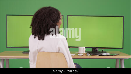 African American medico donna lavora su computer con schermo verde visualizza Foto Stock