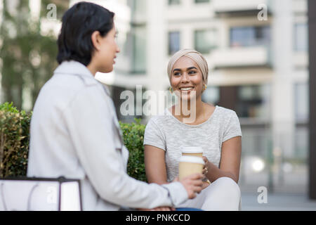 Femmina amici musulmani avente caffè insieme all'aperto Foto Stock