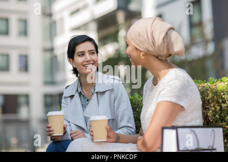 Femmina amici arabi avente caffè insieme all'aperto Foto Stock