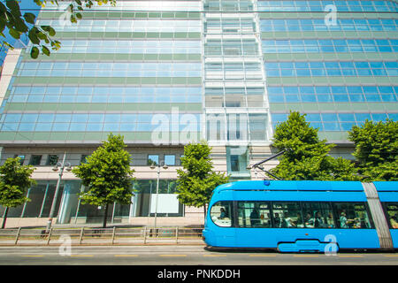 Tram moderno sulla strada a Zagabria in Croazia, nuovo edificio per uffici in background Foto Stock