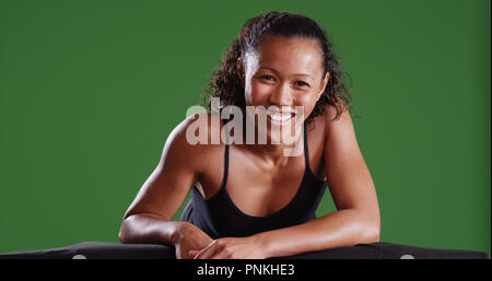 Athletic razza mista sorridente femmina in Telecamera su schermo verde Foto Stock