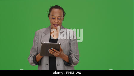 Imprenditrice afro-americano utilizzando dispositivo tablet pc su schermo verde Foto Stock