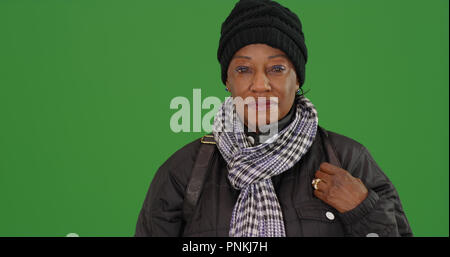 Un vecchio nero donna in caldo abbigliamento invernale su schermo verde Foto Stock