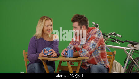 Bianco giovane coppia su Nizza data presso la caffetteria dopo la corsa in bicicletta su schermo verde Foto Stock