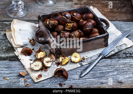 Castagne arrostite in una vecchia scatola. Messa a fuoco selettiva. Foto Stock