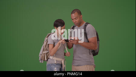 African American giovane cerca per la loro destinazione su schermo verde Foto Stock