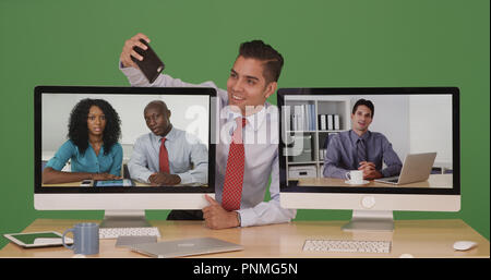 Imprenditore durante la conferenza video tenendo selfie con telefono su schermo verde Foto Stock