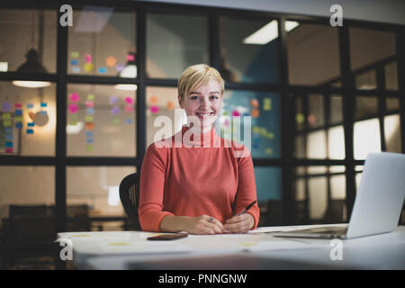 Ritratto giovane femmina adulta lavora fino a tardi in un ufficio Foto Stock