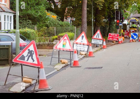 Lavori in corso segni allineati su di una strada nella piccola città nel Regno Unito, dove la qualità delle strade è classificato 27 in tutto il mondo; Luglio 2017 Foto Stock