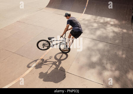 Biciclette BMX rider facendo trucco sulla sua bicicletta Foto Stock