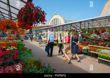 Riga mercato centrale, vista in estate del popolo lettone a piedi attraverso il mercato dei fiori nella centrale area di mercato di Riga, Lettonia. Foto Stock