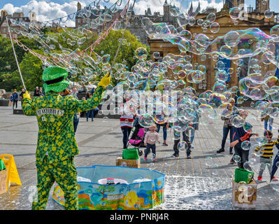 Edimburgo Scozia centro città spettatori coperto con bolle di sapone soffiata nel vento Foto Stock