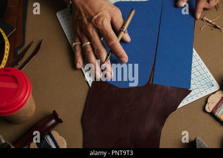 Il processo di lavorazione per la produzione di fatto a mano portafoglio in pelle a pelle officina. Foto Stock