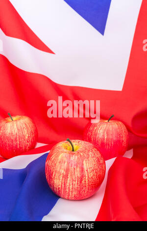 Mele rosse / mela & bandiera del Regno Unito / Union Jack. Per la coltivazione di mele nel Regno Unito, le mele inglesi, l'industria britannica della produzione di sidro, ottobre Apple Day, i prodotti britannici. Foto Stock