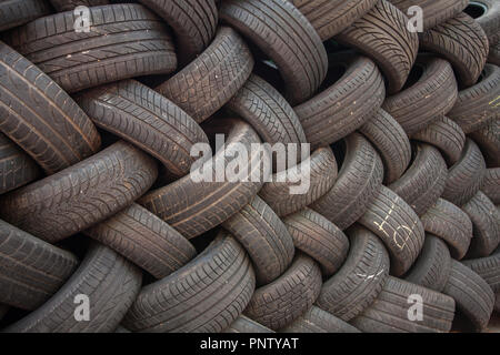 Sfondo, la texture della parete di pneumatici prevista in corrispondenza di un angolo. Nero in gomma di pneumatici, parte del veicolo, parte di ricambio. Foto Stock