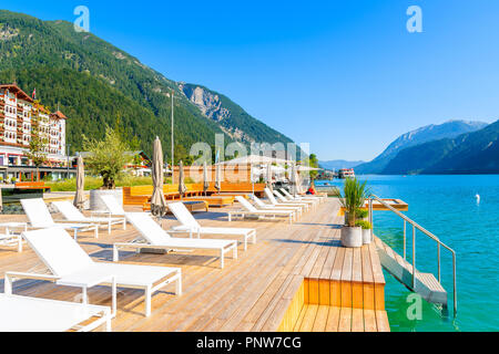 Sedie sul molo a Pertisau cittadina sulla soleggiata giornata estiva sulla riva del lago Achensee, Tirolo, Austria Foto Stock