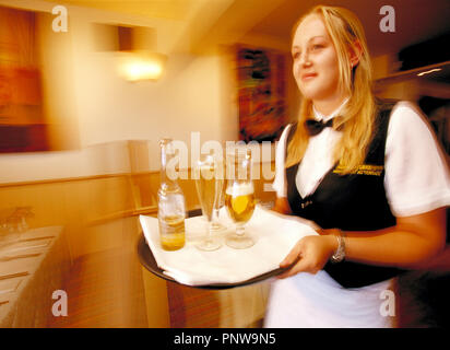 Giovane donna bionda cameriera con vassoio bevande nel ristorante café bar. Foto Stock
