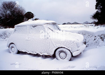 Scena invernale con mini-auto coperto di neve. Isole del Canale. Guernsey. Foto Stock