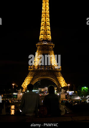 Coppia che guarda la Torre Eiffel di notte Foto Stock
