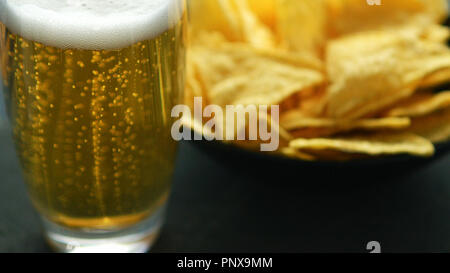 Bicchiere di birra e nacho chips Foto Stock