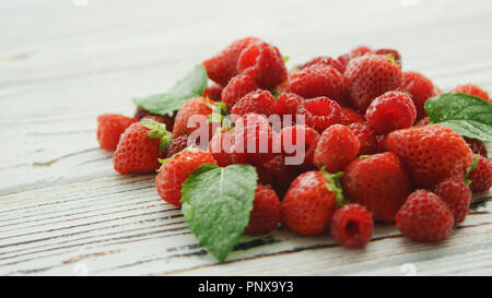 Foglie sul mucchio di frutti di bosco Foto Stock