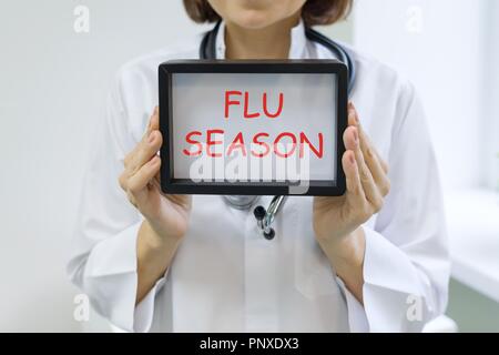 La stagione influenzale testo nelle mani di un medico di sesso femminile. Foto Stock