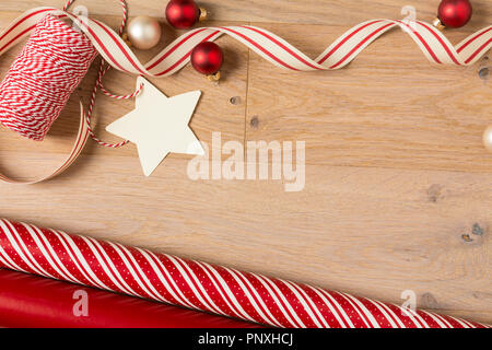 Semplice e in stile country regalo di Natale carta da imballaggio, nastri, decorazioni e blank gift tag in legno rustico sfondo di legno Foto Stock