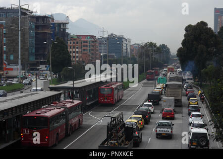 Bogotà, Colombia - 17 Maggio 2017: il traffico sulla carreggiata in direzione sud è praticamente il paraurti al paraurti. A sinistra si trova la stazione di TransMilenio. Foto Stock