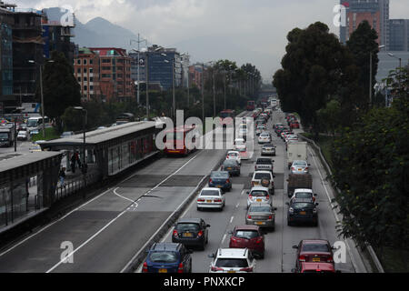 Bogotà, Colombia - 17 Maggio 2017: il traffico sulla carreggiata in direzione sud è praticamente il paraurti al paraurti. A sinistra si trova la stazione di TransMilenio. Foto Stock