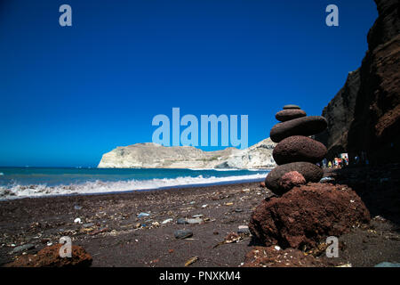 Stone ciottoli accatastati, antico rituale per la buona fortuna e prosperità presso la Spiaggia Rossa vicino al villaggio e antico sito di Akrotiri. Isola di Santorini, G Foto Stock