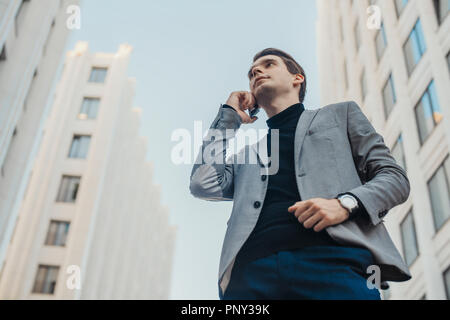 Chiusura del giovane imprenditore parla al telefono cellulare vicino al centro business. Foto Stock