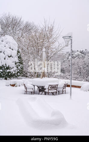 Sedie in metallo e mobili da giardino patio impostare ricoperto di neve in inverno in un giardino nel Surrey, Regno Unito Foto Stock