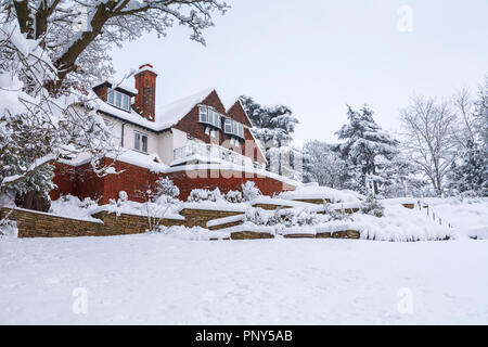 Giardino posteriore vista di una grande casa Tarrant e coperti di neve terrazzamenti a Woking, Surrey, Regno Unito ricoperto di neve durante forti nevicate in inverno Foto Stock