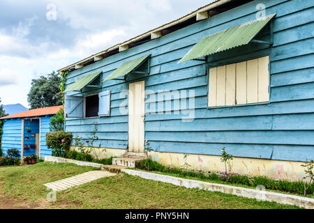 Esterno della casa con il dipinto di blu clapboard o weatherboard schierata in America centrale. Noto anche come schierandosi conico o giro parteggiare. Foto Stock