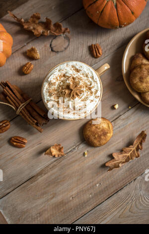 Pumpkin Spice Latte. Tazza di latte con ingredienti di stagione autunno spezie, cookie e decor di caduta. Tradizionale bevanda di caffè per vacanze d'autunno. Foto Stock