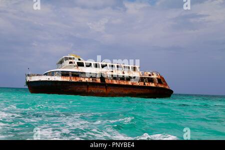 Nave naufragata durante un uragano nei Caraibi con una tempesta edificio dietro di essa Foto Stock