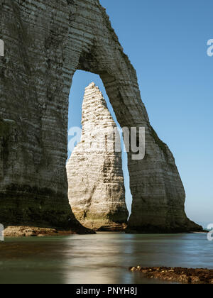 Chalk Scogliere di Etretat Normandia (Francia) con l'arco naturale Porte d'Aval e l'ago di pietra che si chiama l'Aiguille. L'ago è visibile attraverso la Foto Stock