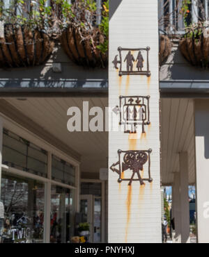 Il vecchio metallo arrugginito wc indicazioni su un palo di legno in una zona esterna Foto Stock