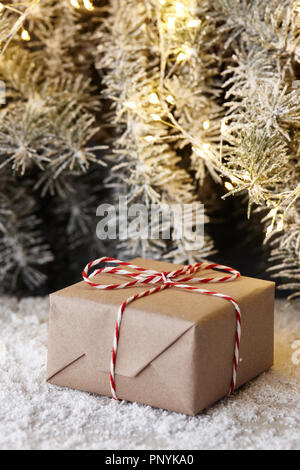 Regalo di natale scatole avvolte in carta kraft sotto snowy Abete rami, spazio di copia Foto Stock