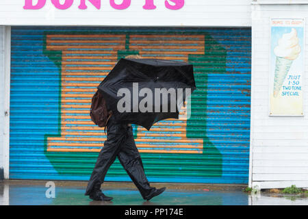 Hastings, East Sussex, Regno Unito. 23rd Set 2018. UK Meteo: Pioggia intensa e vento guida nella città balneare di Hastings questa mattina, le temperature sono scese sotto i 13°C. Quest'uomo perde quasi il suo ombrello mentre una raffica di vento lo trasforma dentro fuori. Photo Credit: Paul Lawrenson / Alamy Live News Foto Stock