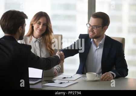 Business Partner per il messaggio di saluto di handshaking a riunione in ufficio Foto Stock