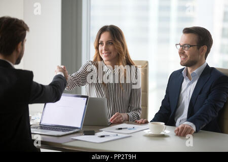 Diversi colleghi agitando la mano durante la riunione di affari offic Foto Stock