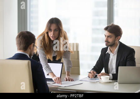 Mad donna che mostra il documento errore partner maschile durante meetin Foto Stock