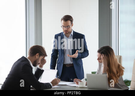 Mad imprenditore mostrare insoddisfazione per il partner alla riunione Foto Stock