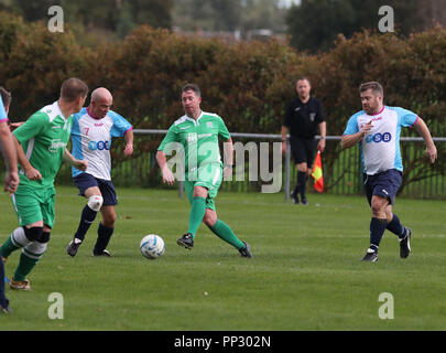 Premere associazione Reporters Rob Merrick (sinistra) e David Wilcock (destra) Chiudere in su ex Liverpool FC e Inghilterra scontrino Robbie Fowler (centro) durante il lavoro (in verde) v giornalisti annuale di partita di calcio a Walton Park a Liverpool Durante il partito della conferenza annuale nella città. Foto Stock