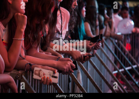 NOVI SAD SERBIA - Luglio 12, 2018: Focus sulle mani di persone in attesa di fronte al palco per un concerto, sms e tenere i loro smartphone, dur Foto Stock