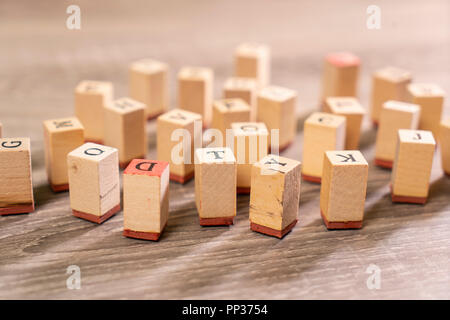 Lettere stampate su cubi di legno sparsi sul tavolo Foto Stock