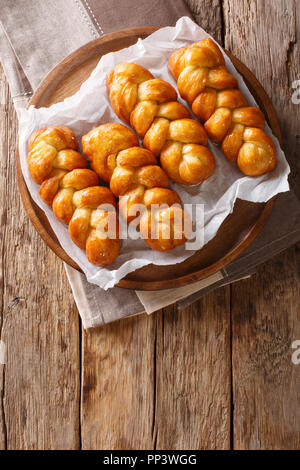 Koeksisters tradizionale South African sticky ciambella dolce, appiccicosa, croccante e intriso di sciroppo, cucita con cannella, limone e zenzero close-up. Verti Foto Stock