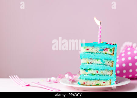 Colorato fetta di torta di compleanno con una candela Foto Stock
