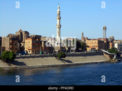 Il minareto della moschea e un'acqua torre domina lo skyline di una piccola città sulle rive del fiume Nilo in Egitto Foto Stock